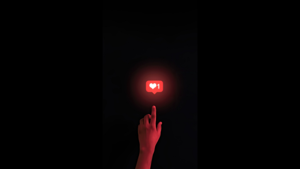 Una mano iluminada de color rojo apunta con un dedo a un ícono de "me gusta" en forma de corazón