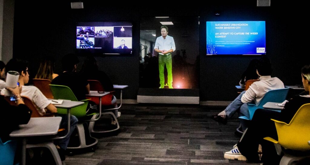 Un profesor da clase a través de un holograma a estudiantes universitarios