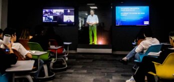 Un profesor da clase a través de un holograma a estudiantes universitarios