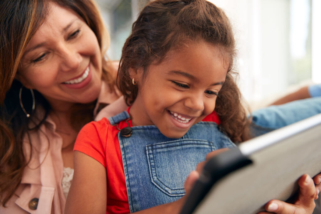 Niña y madre aprendiendo con tecnología