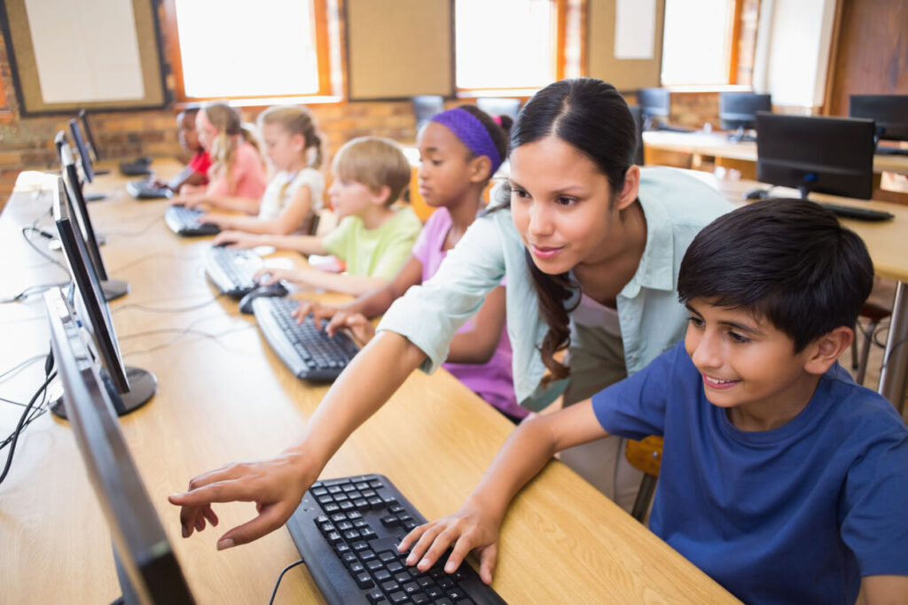 maestra enseñando con tecnología a su alumno