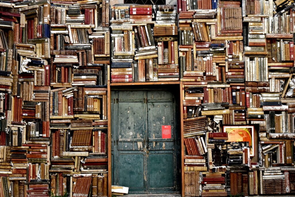 una puerta y muchos libros apilados alrededor