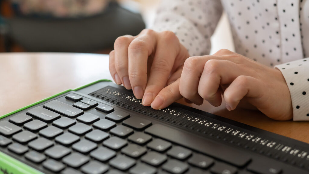Una persona ciega utiliza un teclado braille para escribir.