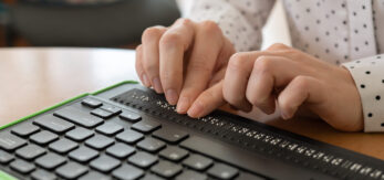 Una persona ciega utiliza un teclado braille para escribir.
