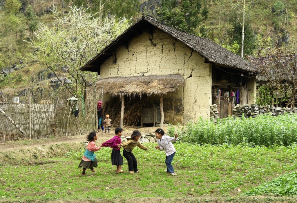 cuatro infantes jugando en patio de casa rural
