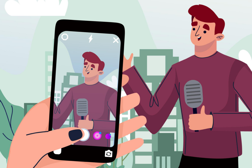 Hombre habla por micrófono mientras otra persona lo graba en su teléfono inteligente.