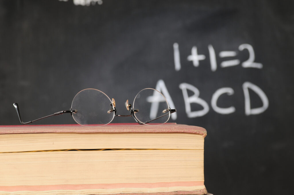 ateojos sobre unos libros y un pizarrón