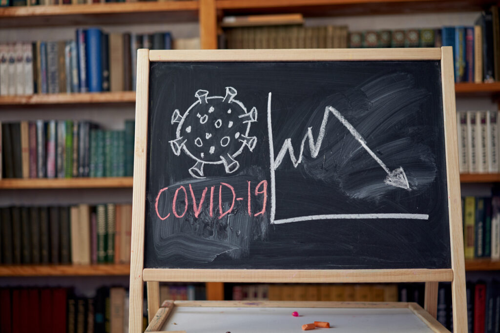 Outbreak Warning. written white chalk on blackboard in connection with epidemic of coronavirus worldwide. Covid 19 pandemic Text on black background with free space. drawn virus bacteria