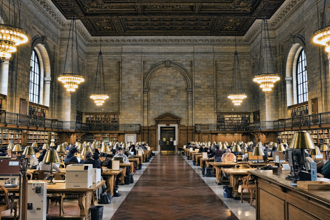 Foto del interior de una biblioteca universitaria grande.